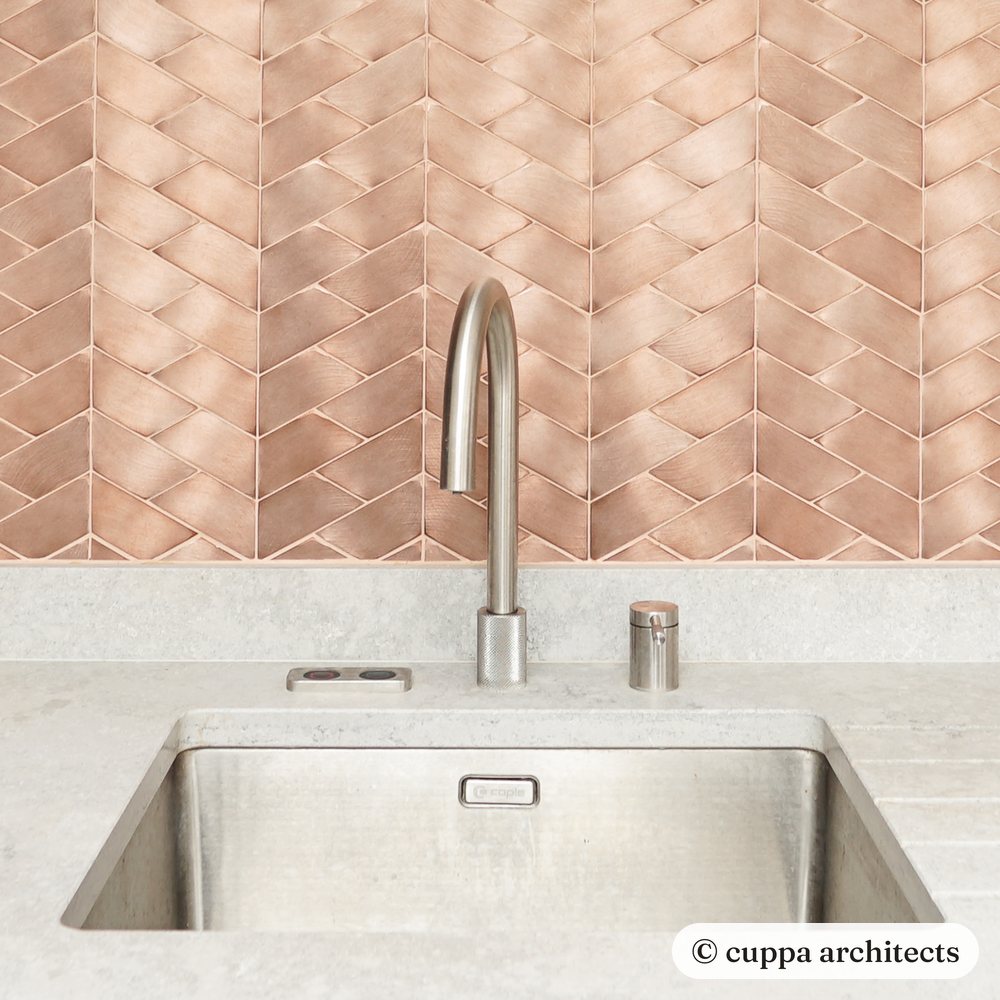 Copper scale tiles behind a kitchen sink, with an oak shelf above