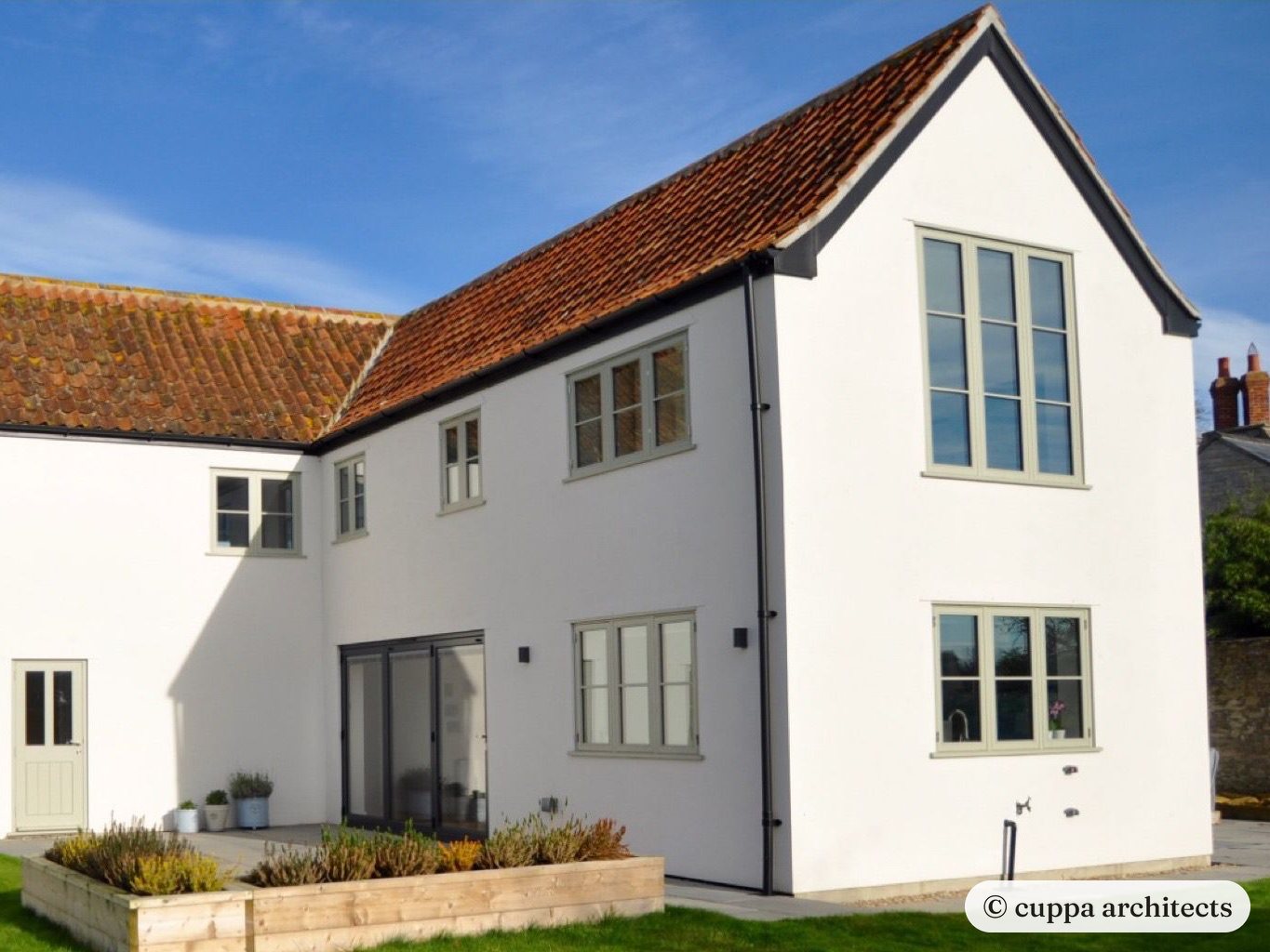 The farmhouse after, with a new two storey wing and tall windows