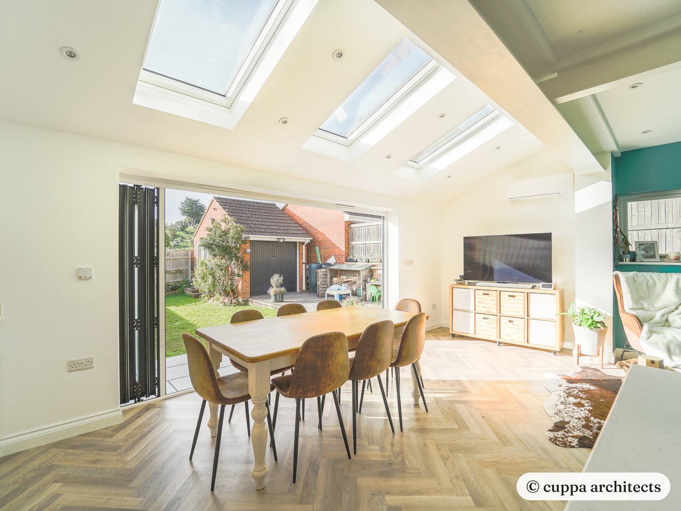 The same extension seen from the kitchen, with herringbone flooring and a teal feature wall