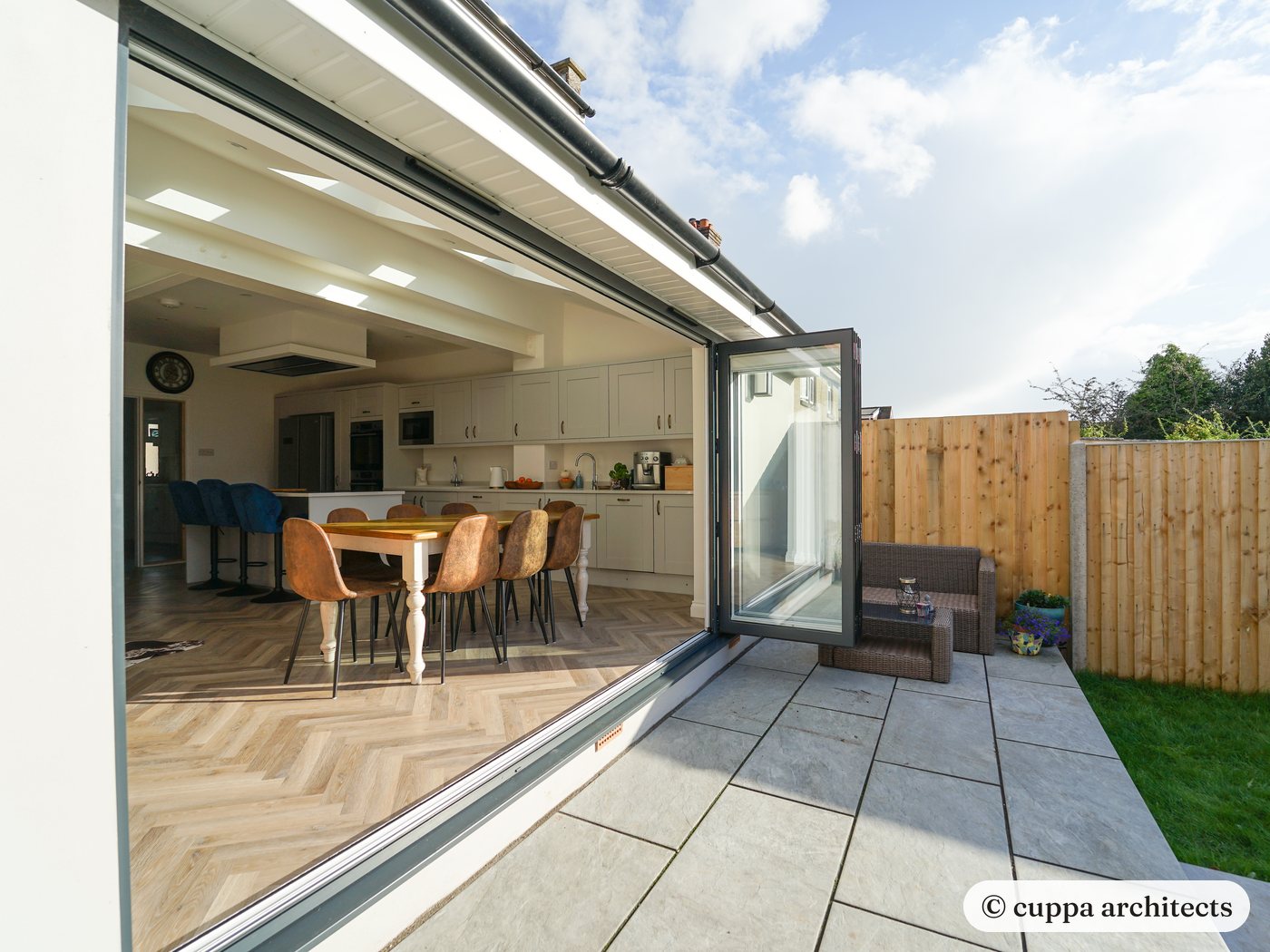 Bifold doors fully open from the extension onto a new patio