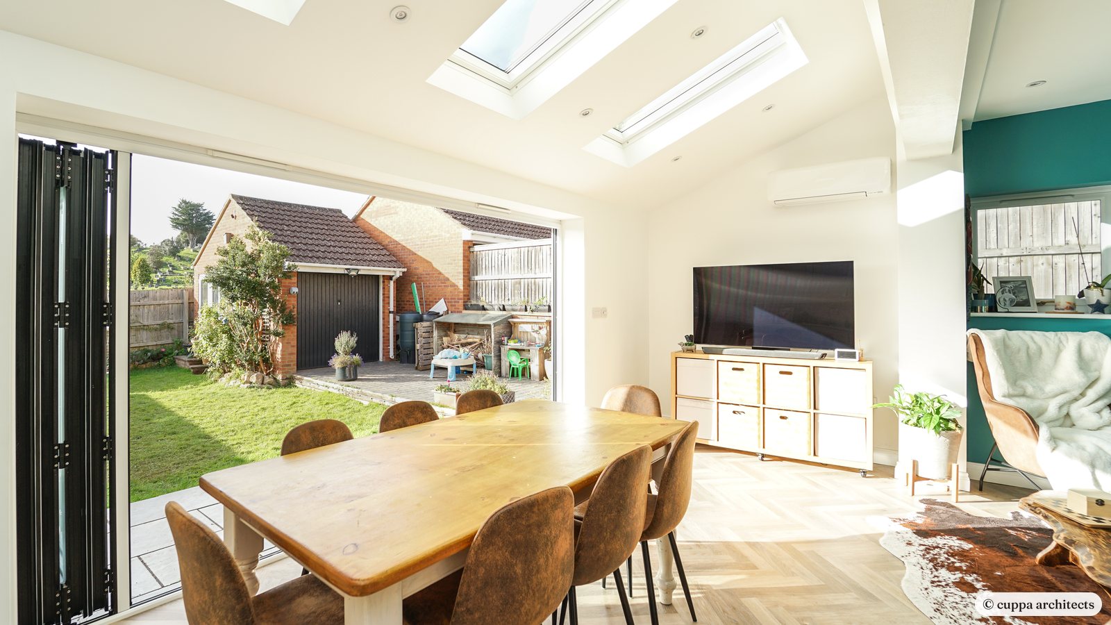 A single storey kitchen and dining extension with rooflights and bifold doors open to the garden