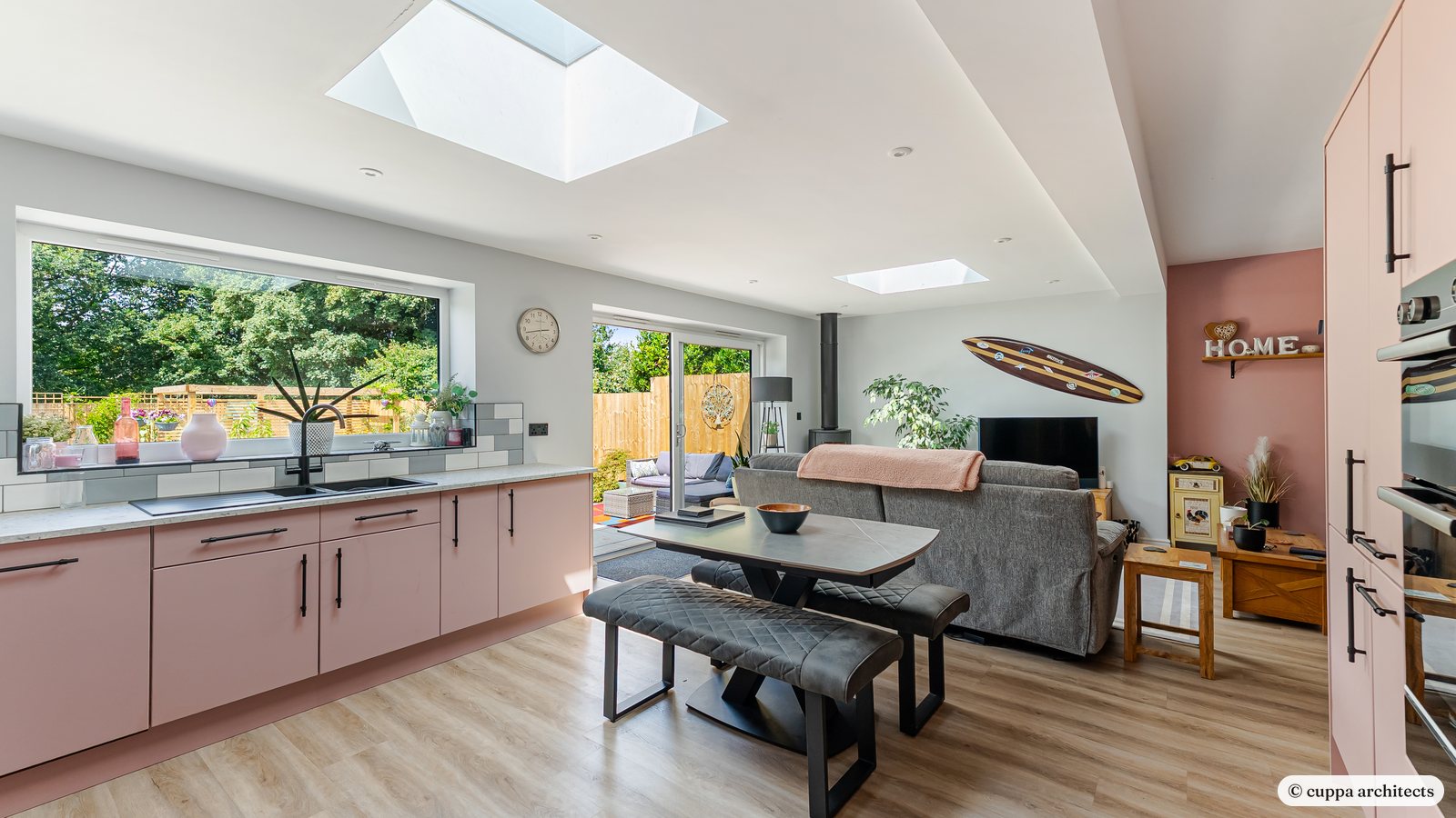 A kitchen extension with a rooflight, a wide garden window and a dining table