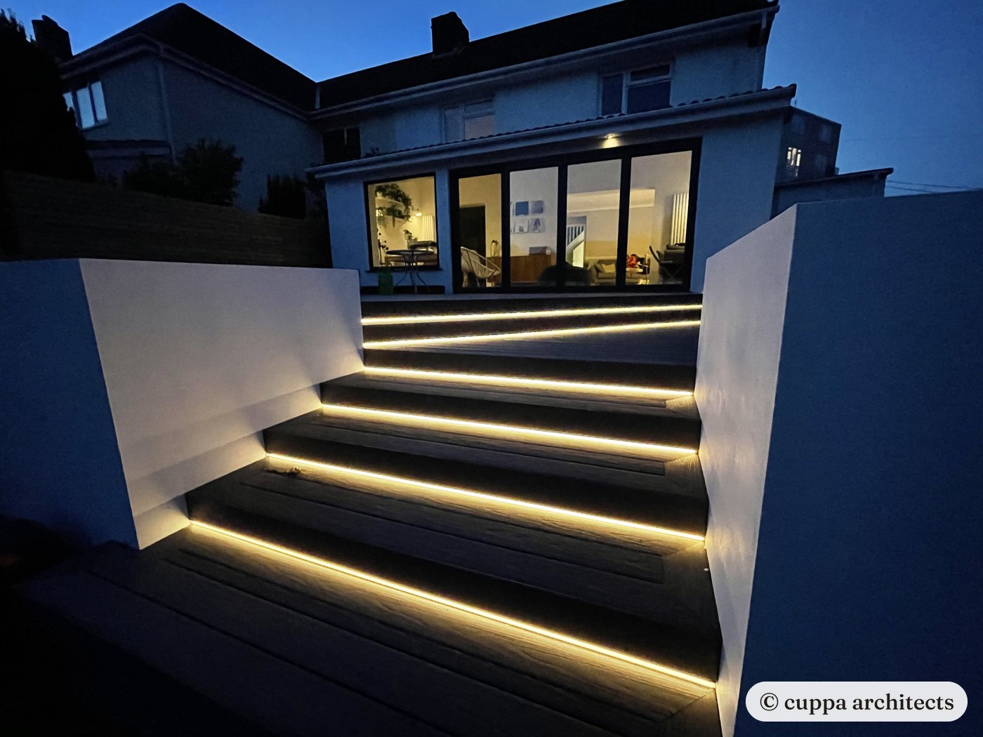 New garden steps lit under each tread, rising from the extension