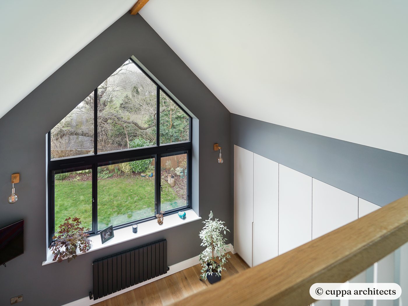 Inside the gable, a tall window frames the garden